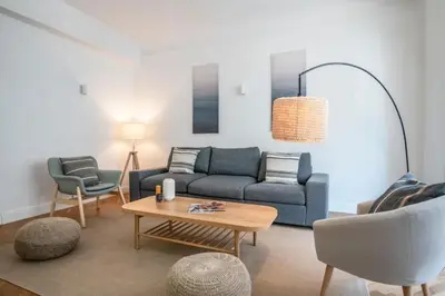 a living room with a blue couch and a table at Le Palais Madrid in Cannes