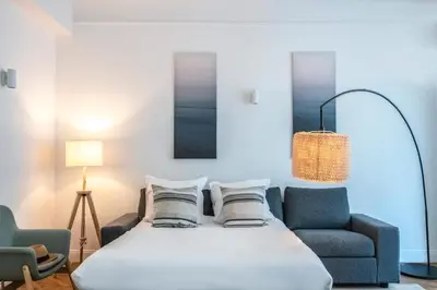 a bedroom with a bed and two chairs and a lamp at Le Palais Madrid in Cannes