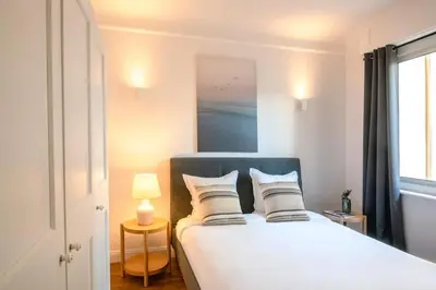 a bedroom with a bed with two pillows and a window at Le Palais Madrid in Cannes