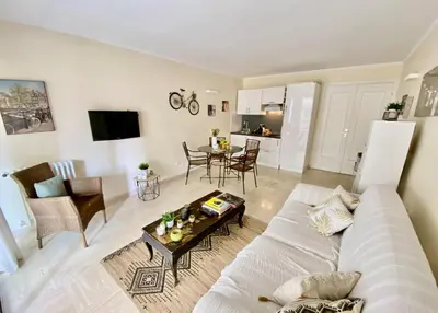 a living room with a white couch and a table at Palais Royal Croisette GIA5407 in Cannes