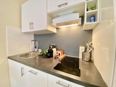 a small kitchen with white cabinets and a sink at Palais Royal Croisette GIA5407 in Cannes