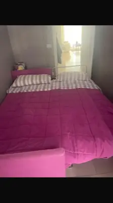 a bed with a pink comforter on top of it at Palais Royal Croisette GIA5407 in Cannes