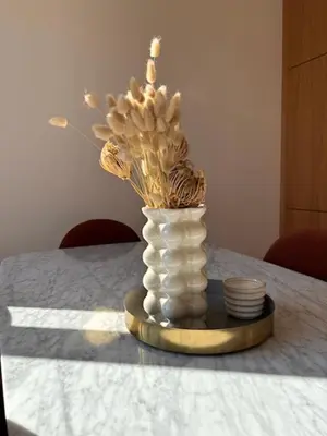 a vase with flowers in it sitting on a table at Superbe appartement Art Déco avec roof top in Cannes