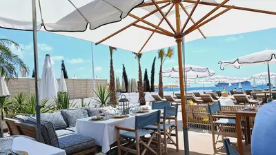 a restaurant with tables and chairs and umbrellas at Superbe appartement Art Déco avec roof top in Cannes