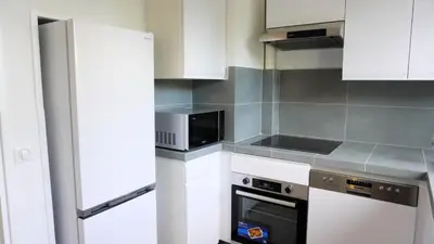 a kitchen with white cabinets and a microwave at Proche Croisette, Appartement 2 Chambres by Palmazur Vacances in Cannes