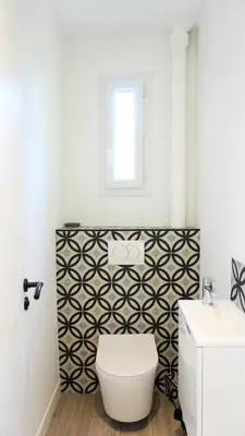 a bathroom with a black and white patterned wall at Proche Croisette, Appartement 2 Chambres by Palmazur Vacances in Cannes