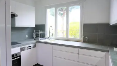 a white kitchen with a sink and a window at Proche Croisette, Appartement 2 Chambres by Palmazur Vacances in Cannes