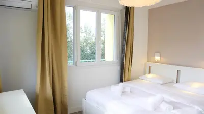 two beds in a room with a window at Proche Croisette, Appartement 2 Chambres by Palmazur Vacances in Cannes