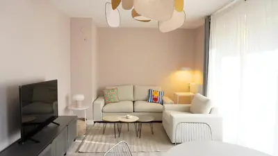 a living room with a couch and a tv at Proche Croisette, Appartement 2 Chambres by Palmazur Vacances in Cannes