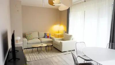a living room with a couch and a table at Proche Croisette, Appartement 2 Chambres by Palmazur Vacances in Cannes
