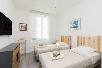 two beds in a room with a tv and a desk at Modern Jaurès-Center-Clim-Wifi-Festival in Cannes