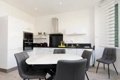 a white kitchen with a white table and chairs at Modern Jaurès-Center-Clim-Wifi-Festival in Cannes