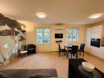 a large living room with a table and chairs at Agréable 2 pièces avec terrasse et jardin in Cannes