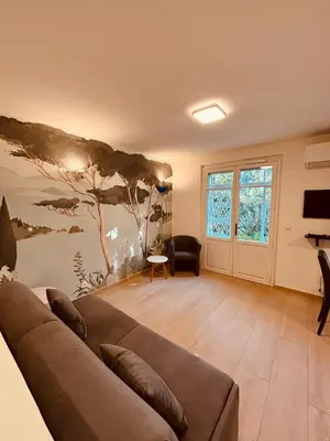a living room with a couch and a window at Agréable 2 pièces avec terrasse et jardin in Cannes