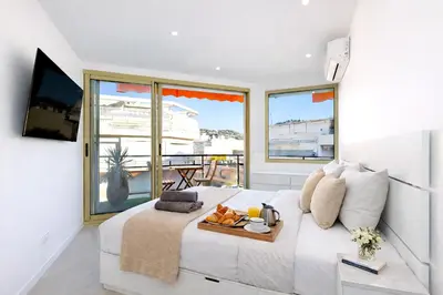 a bedroom with a bed with a tray of food on it at Prestige Maubourg & Exclusive Sea View Terrace in Cannes