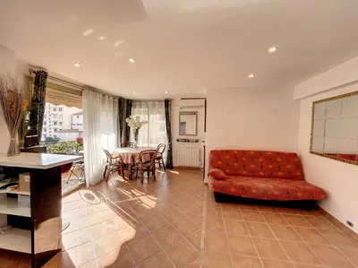 a living room with a red couch and a table at A 2 pas des plages et centre 324L TER in Cannes
