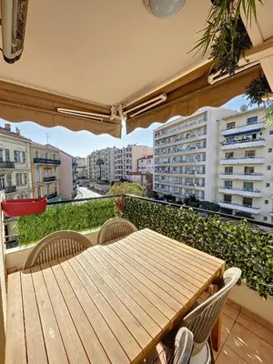 a wooden table and chairs on a balcony at A 2 pas des plages et centre 324L TER in Cannes