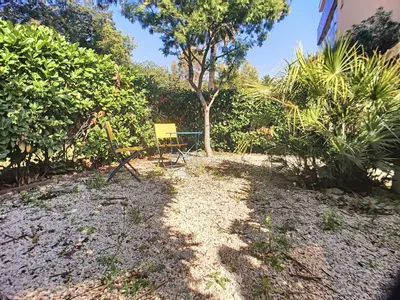 a yellow chair sitting in the middle of a yard at Superbe studio jardin, terrasse, piscine 307L Kali in Cannes