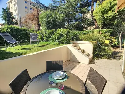 a patio with a table and chairs on a patio at Superbe studio jardin, terrasse, piscine 307L Kali in Cannes