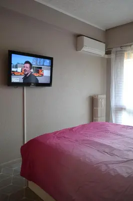 a bedroom with a bed and a tv on the wall at Cannes La Baronne in Cannes