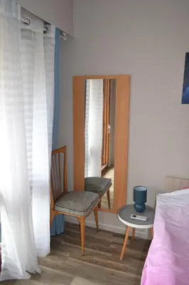a bedroom with a chair and a table and a mirror at Cannes La Baronne in Cannes