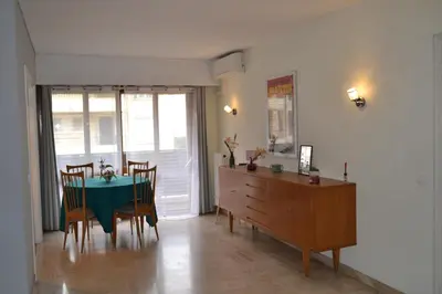a dining room with a green table and chairs at Cannes La Baronne in Cannes