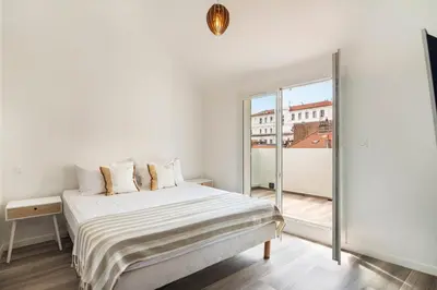 a white bedroom with a bed and a large window at 3 bedrooms 2 terraces in Cannes in Cannes