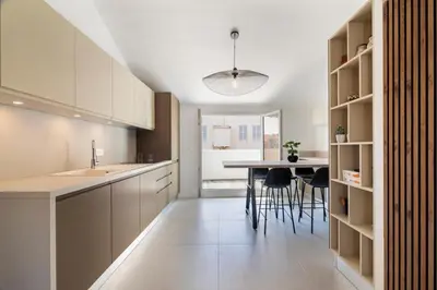 a kitchen with white cabinets and a table and chairs at 3 bedrooms 2 terraces in Cannes in Cannes