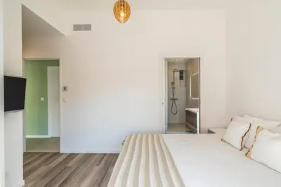 a white bedroom with a bed and a television at 3 bedrooms 2 terraces in Cannes in Cannes