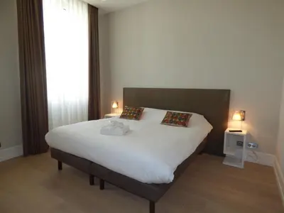 a bedroom with a large white bed with two lamps at Arthur Properties Croisette in Cannes