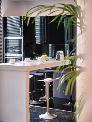 a kitchen with a counter and a bar with stools at Arthur Properties Croisette in Cannes