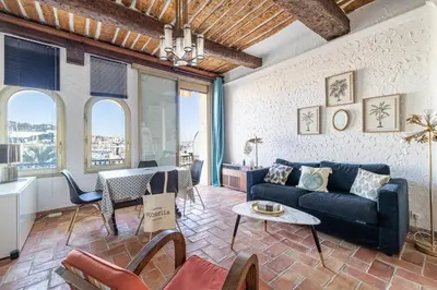 a living room with a couch and a table at L'HONORAT vue mer et port, à côté des plages du Midi et proche du Palais in Cannes