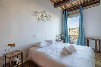 a bedroom with a bed with pillows and a window at L'HONORAT vue mer et port, à côté des plages du Midi et proche du Palais in Cannes