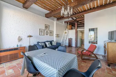 a living room with a table and a couch at L'HONORAT vue mer et port, à côté des plages du Midi et proche du Palais in Cannes