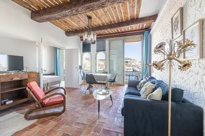 a living room with a blue couch and chairs at L'HONORAT vue mer et port, à côté des plages du Midi et proche du Palais in Cannes