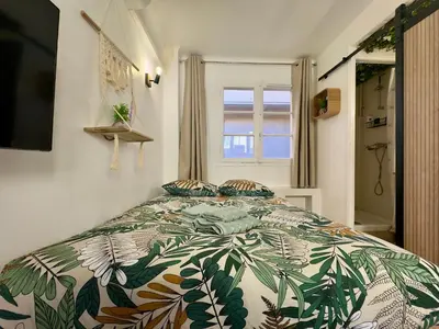 a bedroom with a bed with a green and white comforter at Haute-Rive By SCLS Locations in Cannes