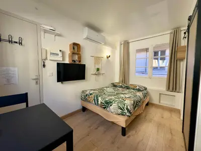 a bedroom with a bed and a table and a television at Haute-Rive By SCLS Locations in Cannes