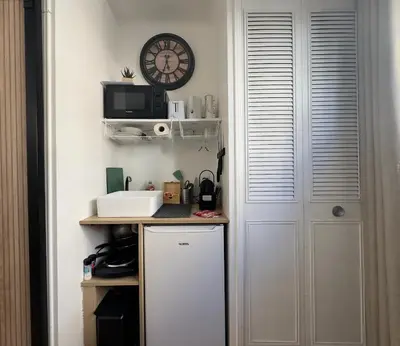 a kitchen with a white door and a clock on the wall at Haute-Rive By SCLS Locations in Cannes