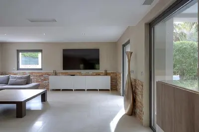 a living room with a couch and a tv at Villa Spacieuse - Piscine chauffée - Climatisé in Mougins