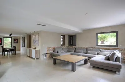 a living room with a couch and a table at Villa Spacieuse - Piscine chauffée - Climatisé in Mougins