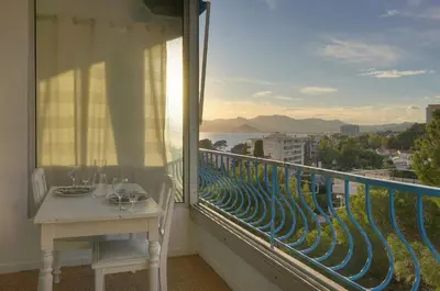 a balcony with a table and a view of the ocean at Immogroom -Studio-Clim-Sea view in Cannes