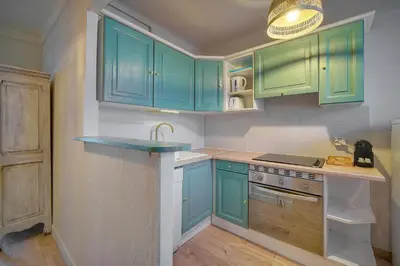 a kitchen with green cabinets and a sink at Immogroom -Studio-Clim-Sea view in Cannes