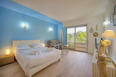 a bedroom with a large bed with a blue wall at Immogroom -Studio-Clim-Sea view in Cannes