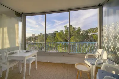 a room with a table and chairs and a large window at Immogroom -Studio-Clim-Sea view in Cannes