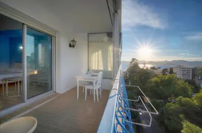 a balcony with a table and a view of the ocean at Immogroom -Studio-Clim-Sea view in Cannes