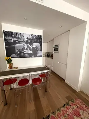 a kitchen with a table and red chairs in a room at Superbe studio pour congrés au coeur de Cannes in Cannes