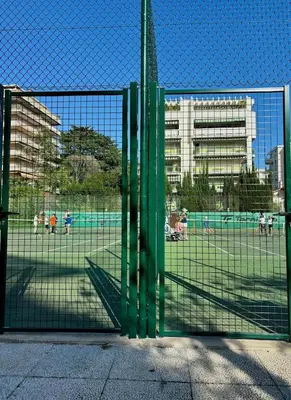 a gate with people playing soccer in a field at Superbe studio pour congrés au coeur de Cannes in Cannes