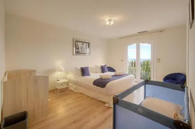 a bedroom with a large bed and a window at IMMOGROOM - Exceptional Villa - Sea View - Pool in Vallauris