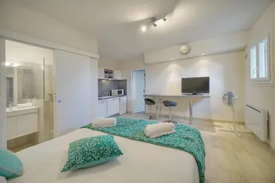 a bedroom with a large bed and a kitchen at IMMOGROOM - Exceptional Villa - Sea View - Pool in Vallauris
