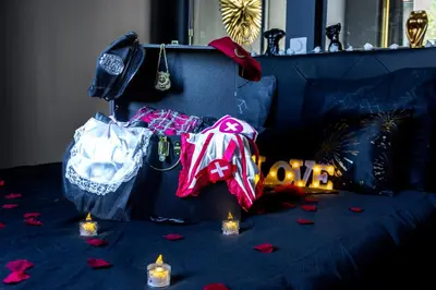 a room with a couch with clothes and lit candles at La Suite Tentation in Cannes
